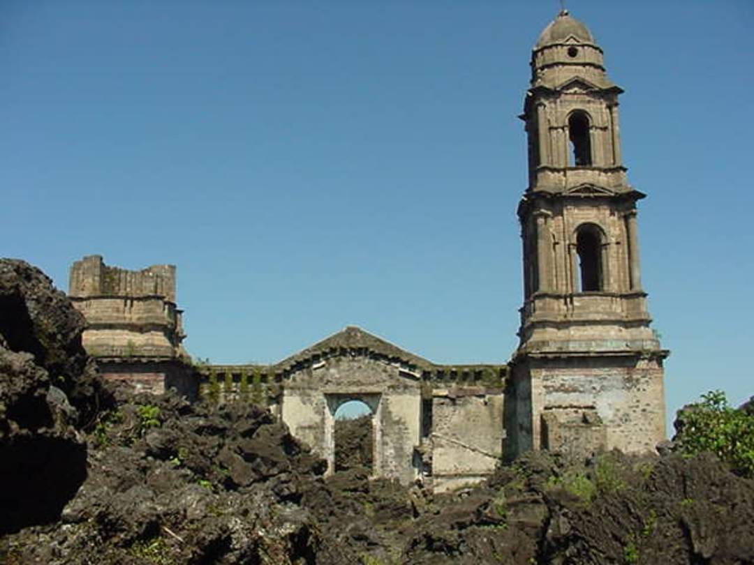 Iglesia de piedra en ruinas rodeada de rocas volcánicas en San Juan Parangaricutiro.