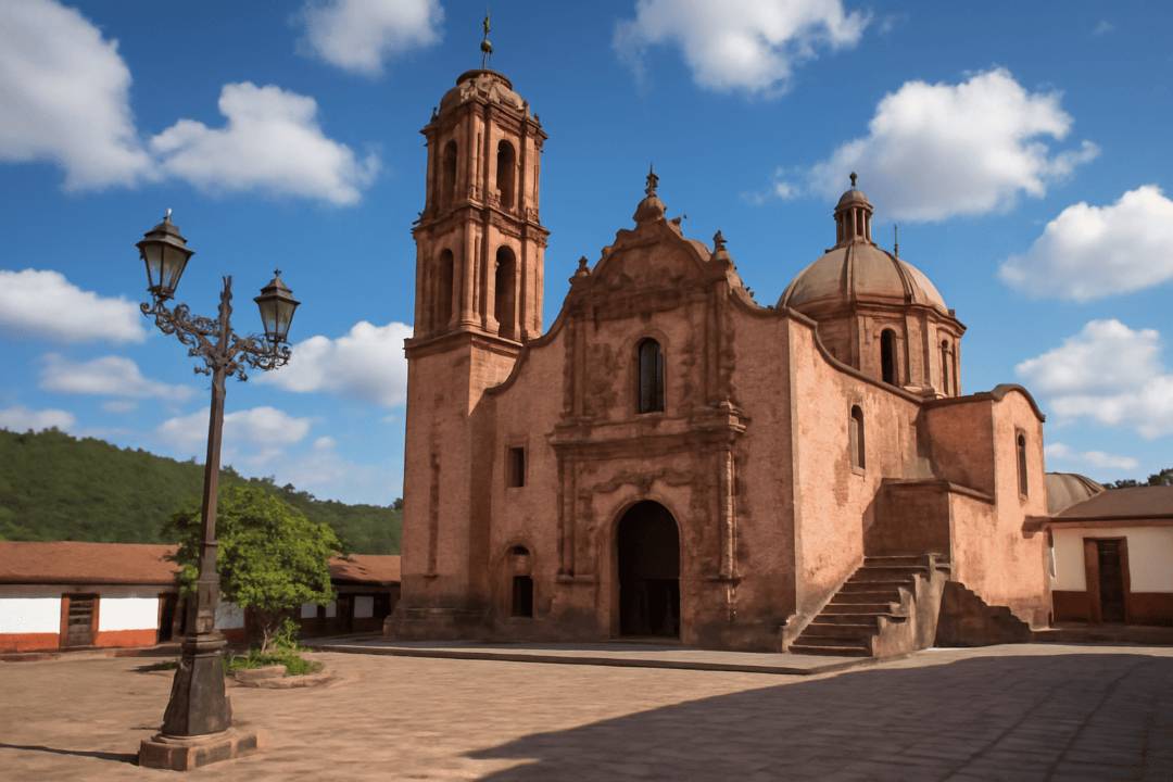 Iglesia del Carmen en Tlalpujahua con torre y cúpula bajo cielo azul.