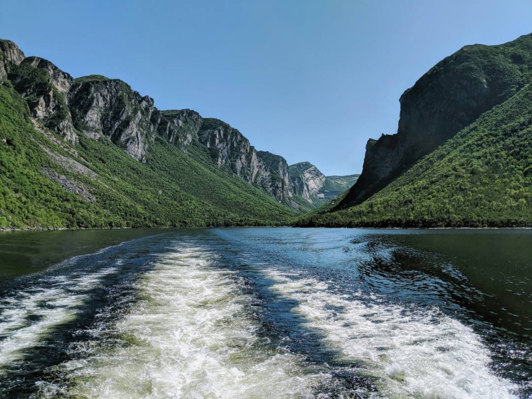 View of Gros Morne National Park's glacial valley, showcasing barren, rust-colored peridotite landscape from Earth's upper mantle.